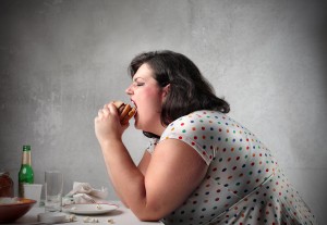 bigstock_Fat_woman_eating_a_hamburger_12163661